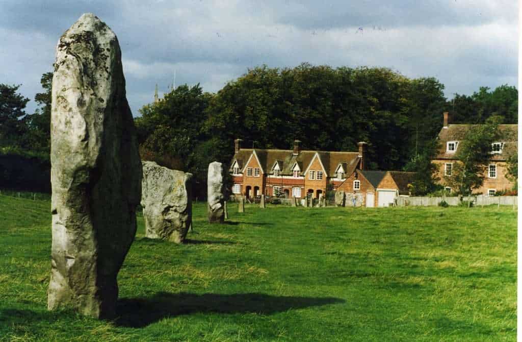 12 Best Day Trips from London (By Travel Bloggers + Map) 4 Ancient standing stones in a lush green field with a charming village in the background, perfect for.