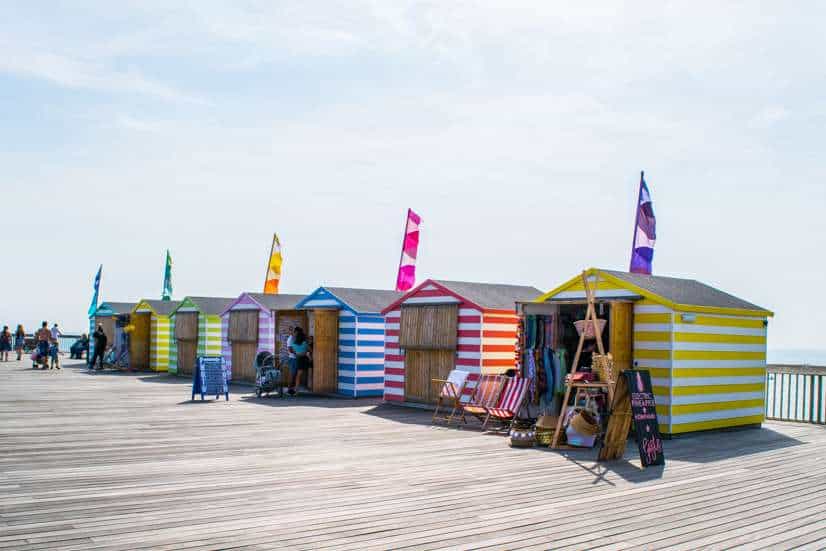 12 Best Day Trips from London (By Travel Bloggers + Map) 18 Vibrant beach huts on a pier, perfect for seaside day trips from London.