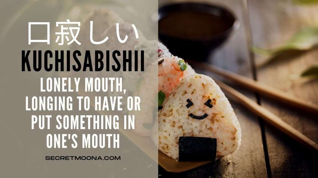 Kuchisabishii (口寂しい) or lonely mouth, shown beside an onigiri rice ball with a smiling face drawn in nori seaweed