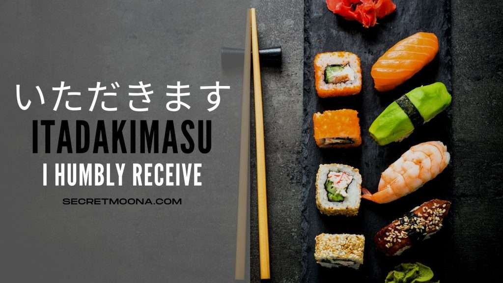 Itadakimasu (いただきます) meaning I humbly receive, shown beside a slate board of sushi and maki rolls with wooden chopsticks