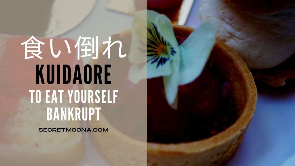 Kuidaore (食い倒れ) meaning to eat yourself bankrupt, shown beside a fruit tart topped with a pale edible pansy