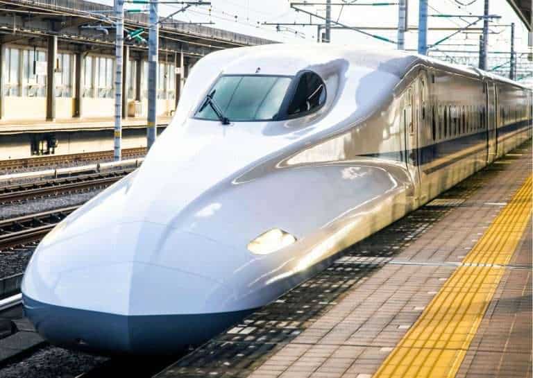 Express white high speed bullet train at track in Japan - Japan Rail Passes