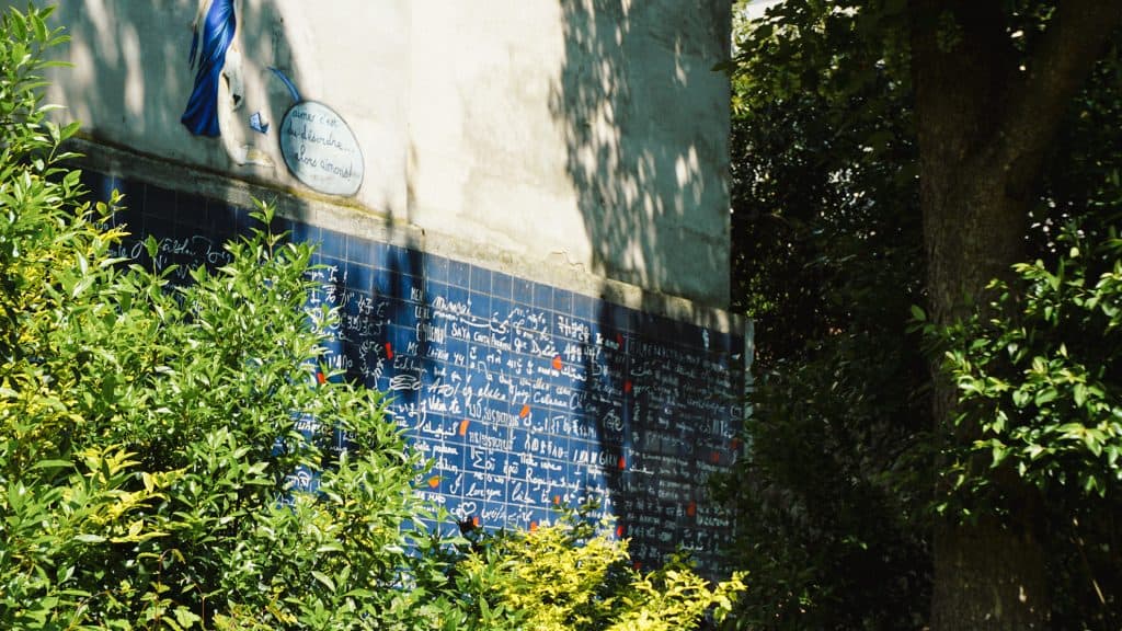 Wall of Je t’Aime surrounded by greenery - Montmartre, Paris