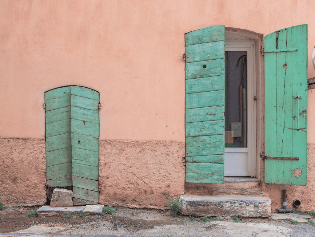 Exploring the Regions of France _ All You Need to Know 24 Green door and window with pink facade in Corsica region - France