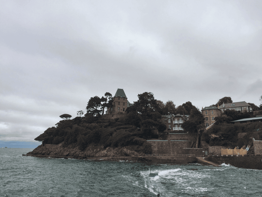 Things To Do In Brittany, France: A Journey Through Scenic Landscapes, And Authentic Culture. 12 A house on a hill with trees and a boat in the water, Dinard - Brittany France