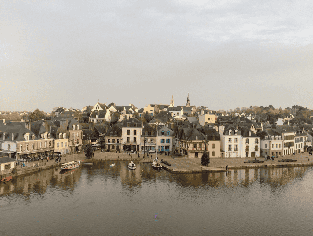 Things To Do In Brittany, France: A Journey Through Scenic Landscapes, And Authentic Culture. 20 A serene riverside town in Brittany, France, with traditional architecture during twilight.