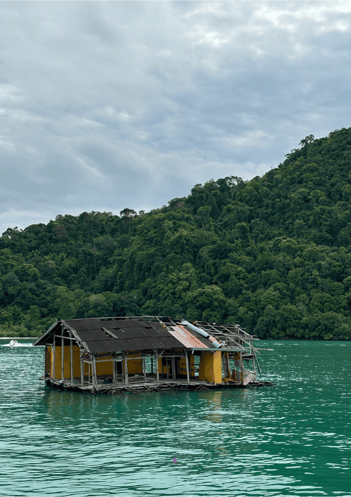 A charming houseboat floating on the ocean, showcasing a unique aspect of a Malaysia travel itinerary.