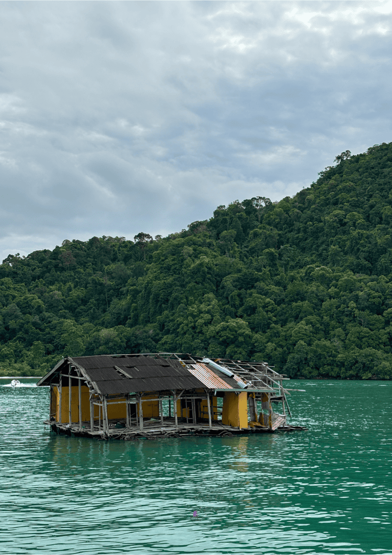 A charming houseboat floating on the ocean, showcasing a unique aspect of a Malaysia travel itinerary.