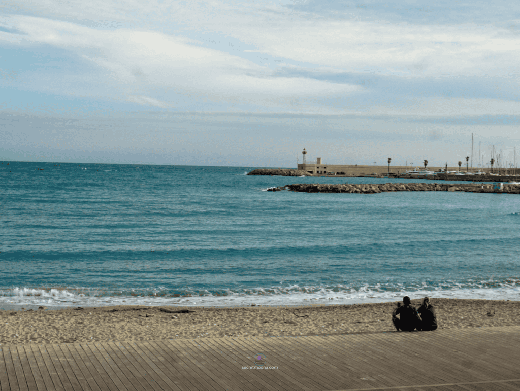 The Perfect One Day in Menton Itinerary: Discover Hidden Gems 20 Two people sitting on the sand, looking at the sea in Menton