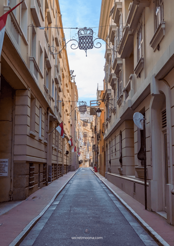 A vibrant narrow street in Monaco, lined with colorful buildings and charming shops, perfect for a day trip adventure.