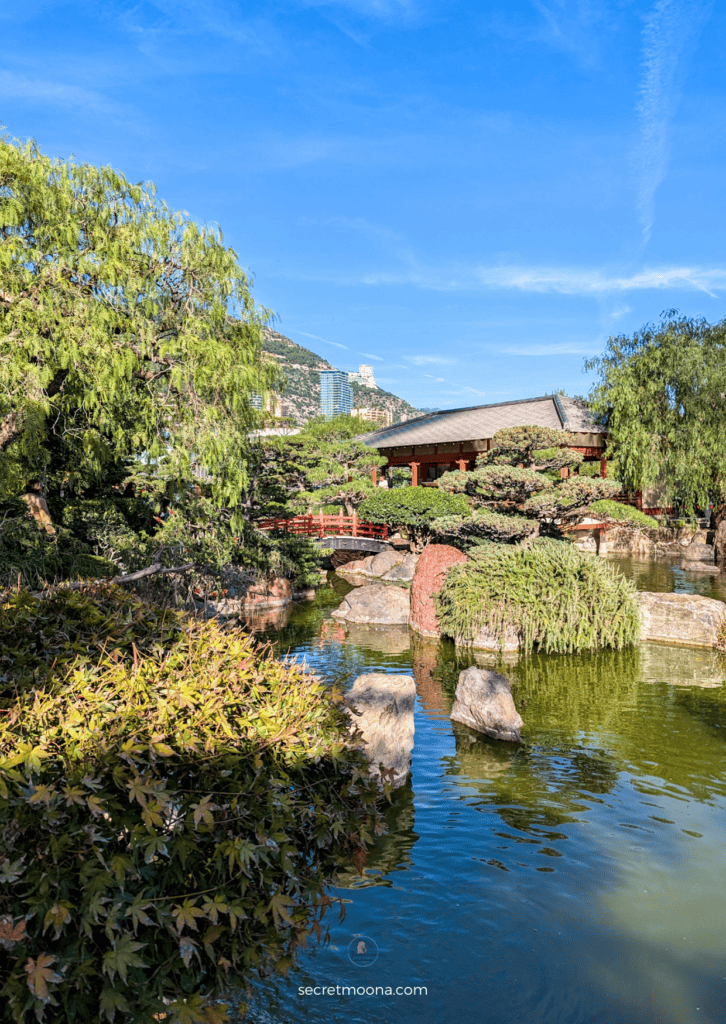 Scenic view of a pond with a bridge and trees, ideal for enjoying a picturesque day trip to Monaco.