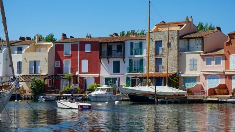 A boat is docked in front of colorful houses in Port Grimaud, France