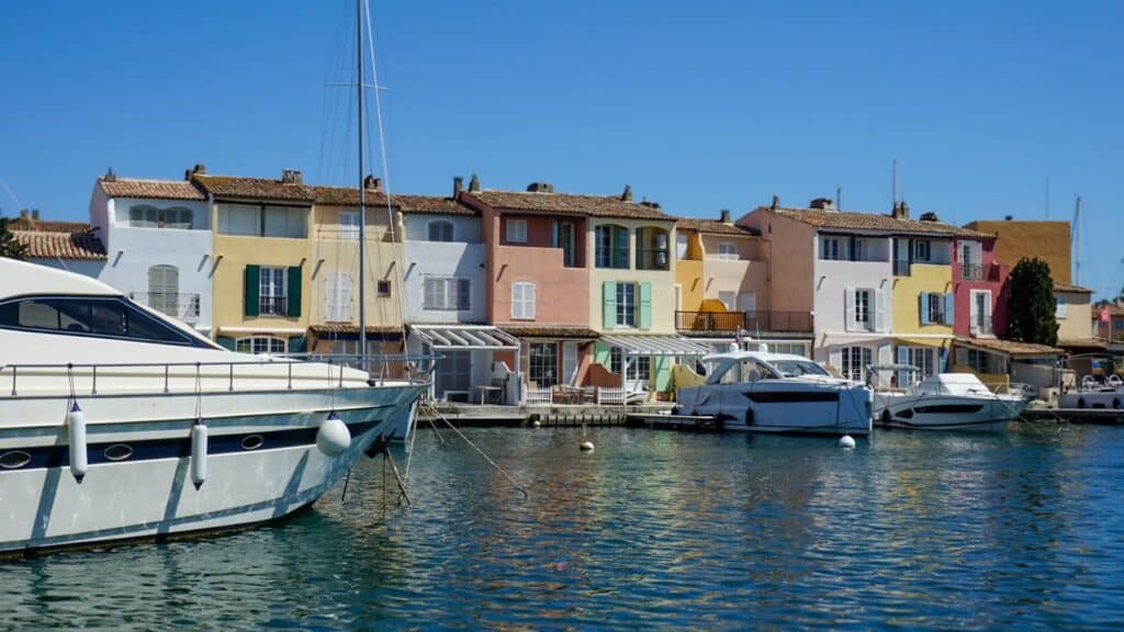France Travel Guide: Regions, Itineraries & Hidden Gems 15 A boat is docked in front of colourful houses in Port Grimaud, France