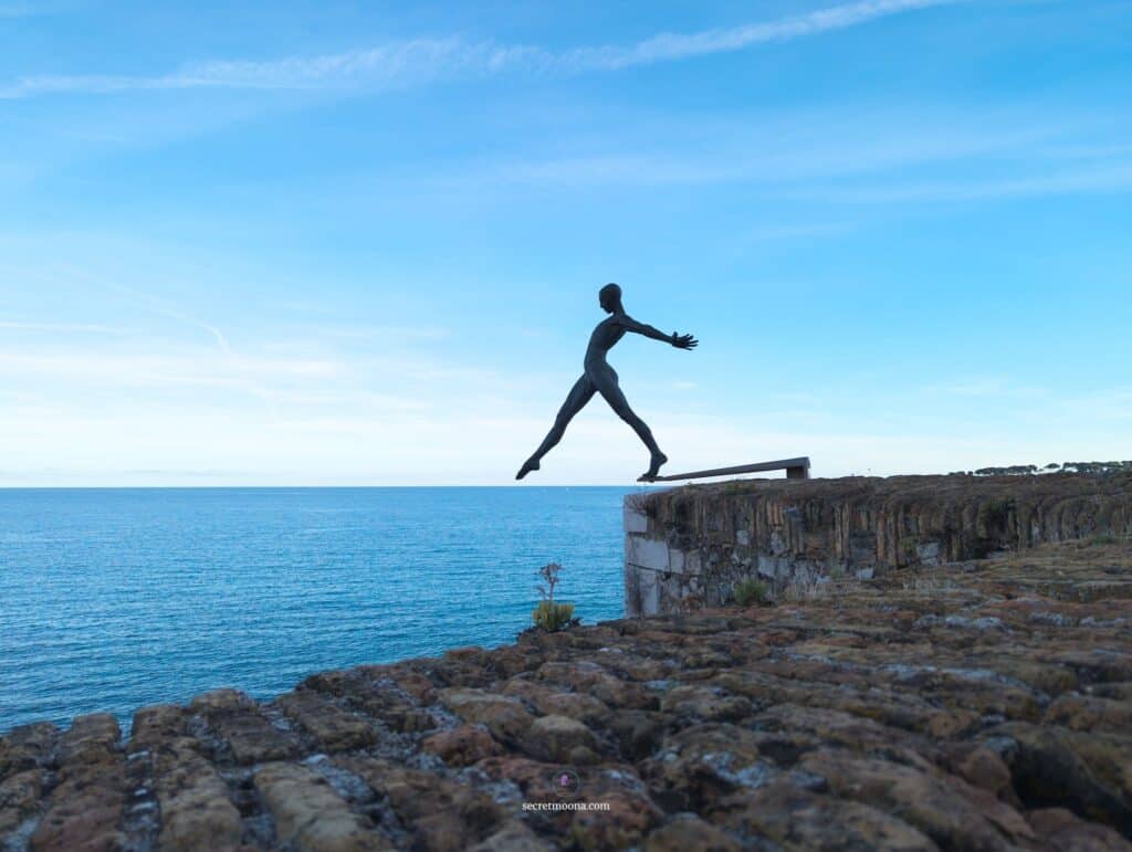 Défi sculpture by Nicolas Lavarenne appearing to dive toward the Mediterranean in Antibes. Things to do in Antibes on a day trip