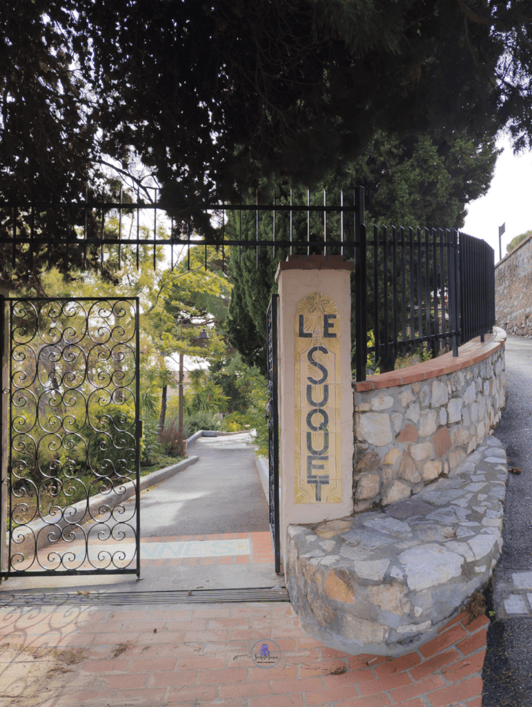 Entrance to Le Suquet old town in Cannes with decorative gate and stone pathway leading down toward the Mediterranean.