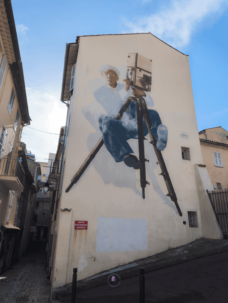 Vibrant mural depicting a photographer capturing scenic views in Cannes, France.