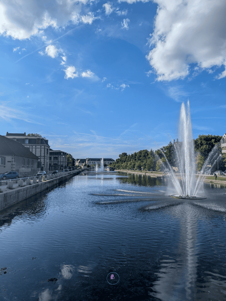 Water fountains on the canal in Troyes under a bright blue sky