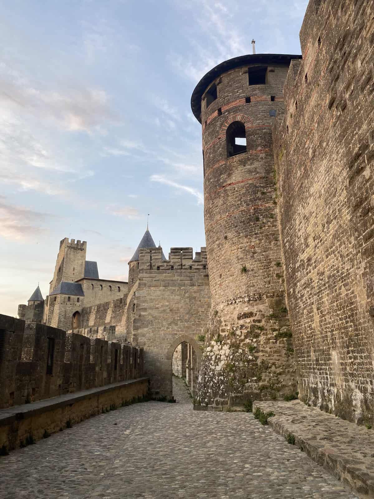 Cobblestone path beside the towers and ramparts of the medieval citadel of Carcassonne, one of the most beautiful towns in France