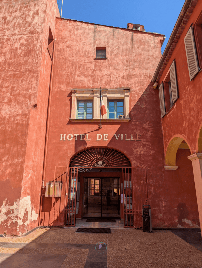 How To Spend One Day In Villefranche-sur-Mer: Things To Do 16 Ochre town hall building in Villefranche-sur-Mer with shuttered windows and Riviera architecture