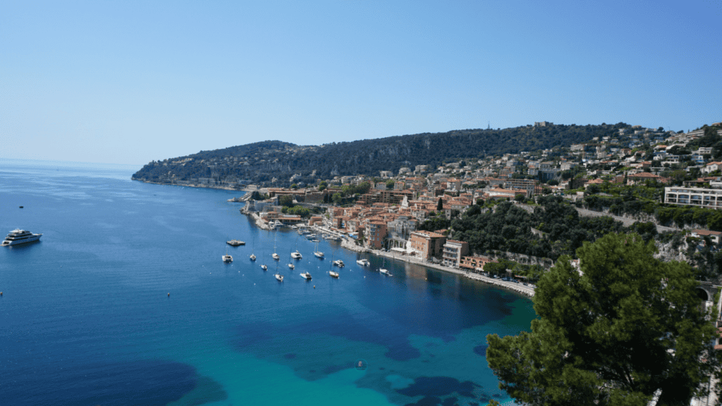 How To Spend One Day In Villefranche-sur-Mer: Things To Do 6 Panoramic view over Villefranche-sur-Mer bay with sailboats and turquoise Mediterranean water