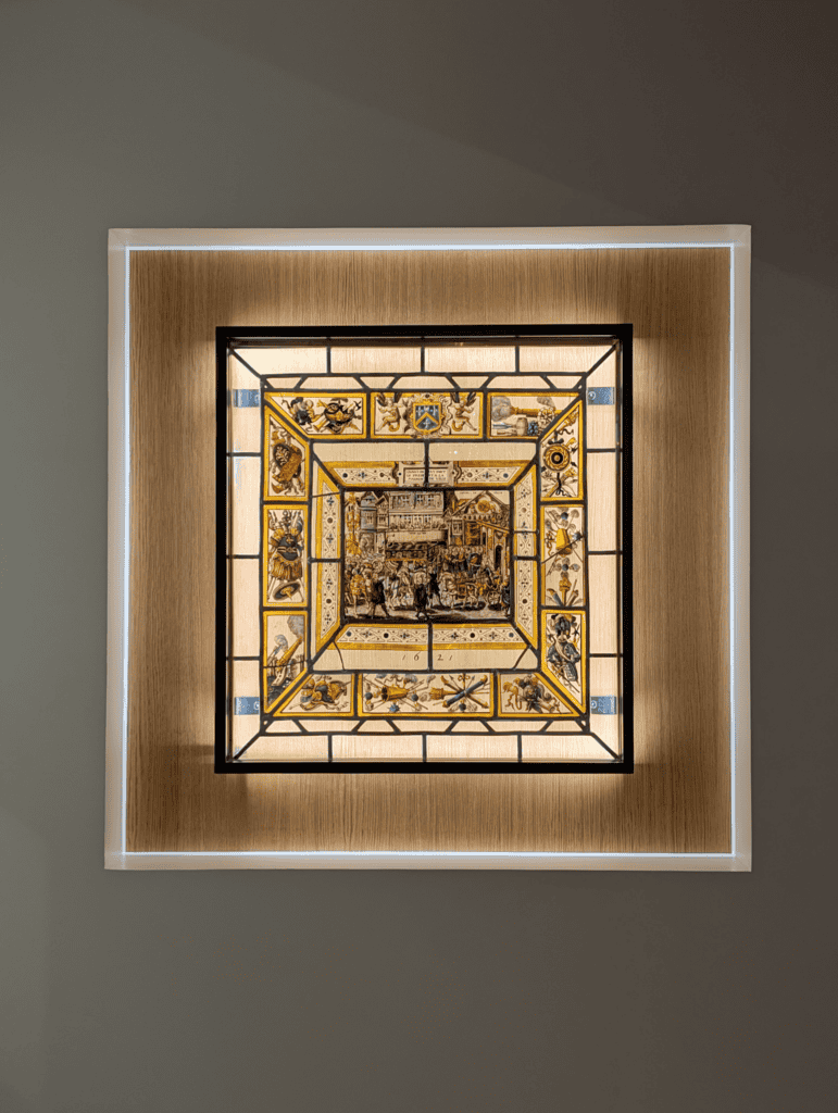 Illuminated historic stained glass panel displayed inside a Troyes museum