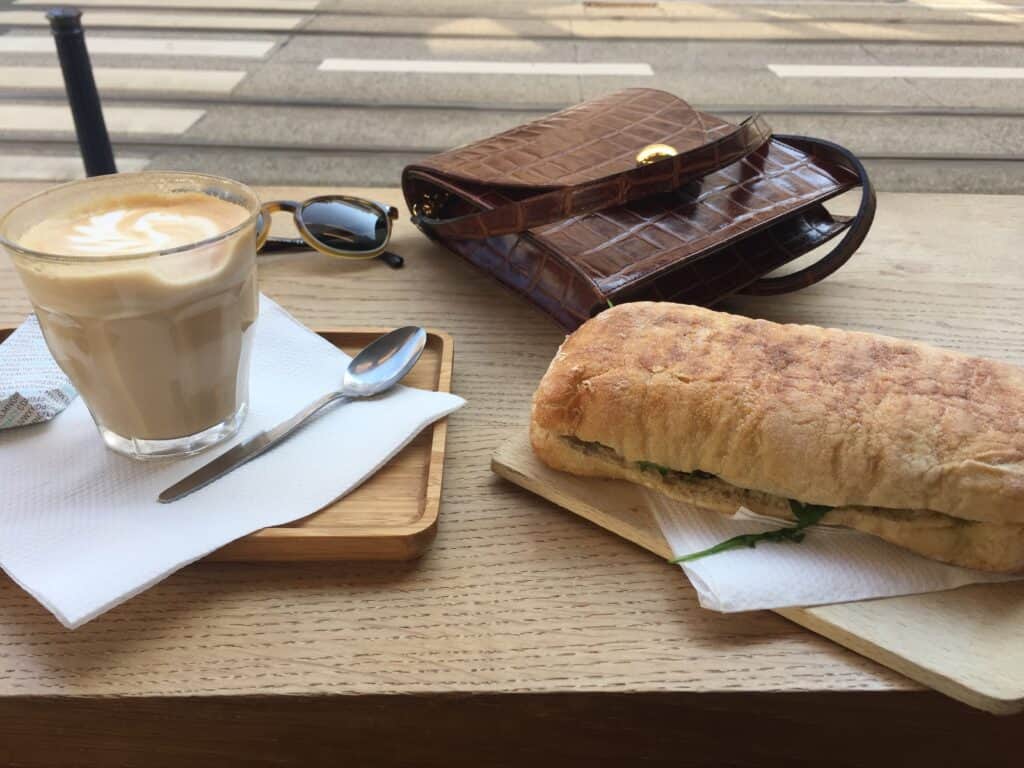 My Favourite Travel Resources: The Websites I Use to Plan and Book Trips 6 Coffee, pastry, and accessories on a wooden table at a café.