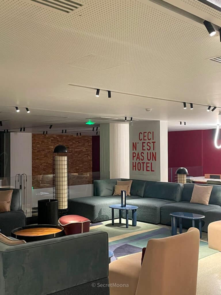Contemporary lounge at TRIBE Paris Pantin with blue sofas and statement wall art