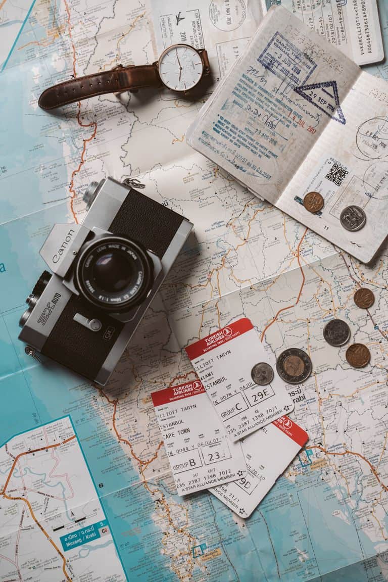 My Favourite Travel Resources. Flat lay travel essentials including passports, tickets, and a vintage camera on a world map.