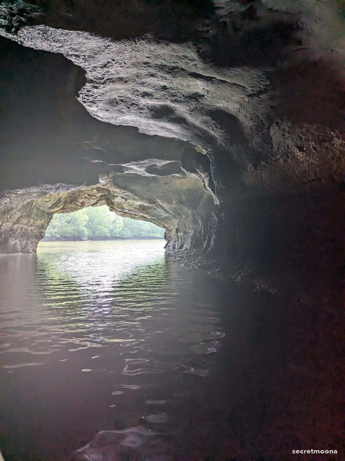 The low arch of Crocodile Cave seen from a boat at Kilim Karst Geoforest Park