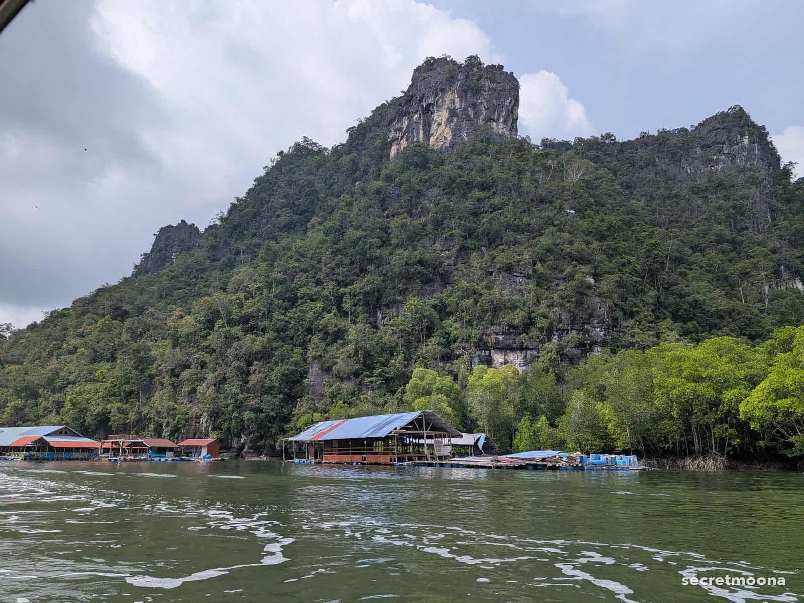 A floating restaurant and fish farm beneath a limestone karst at Kilim