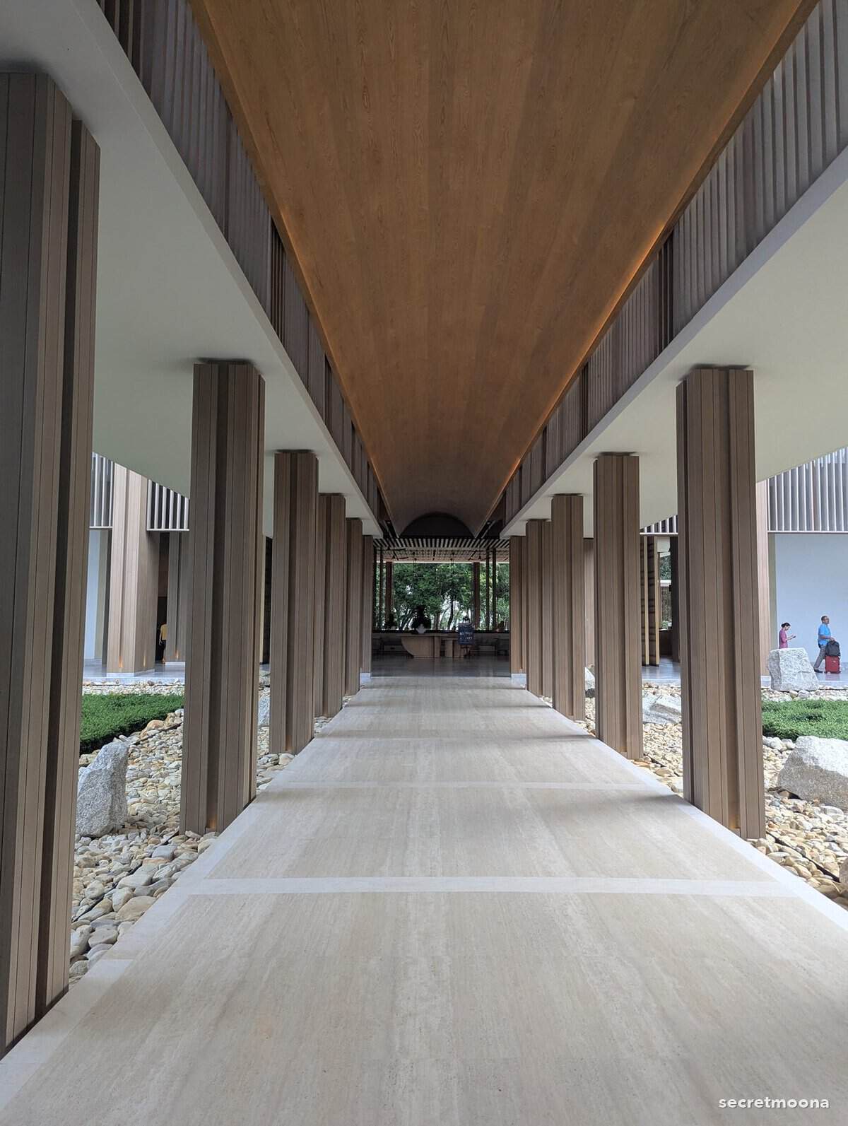 A long covered walkway with timber columns connecting the wings at Hilton Burau Bay Langkawi