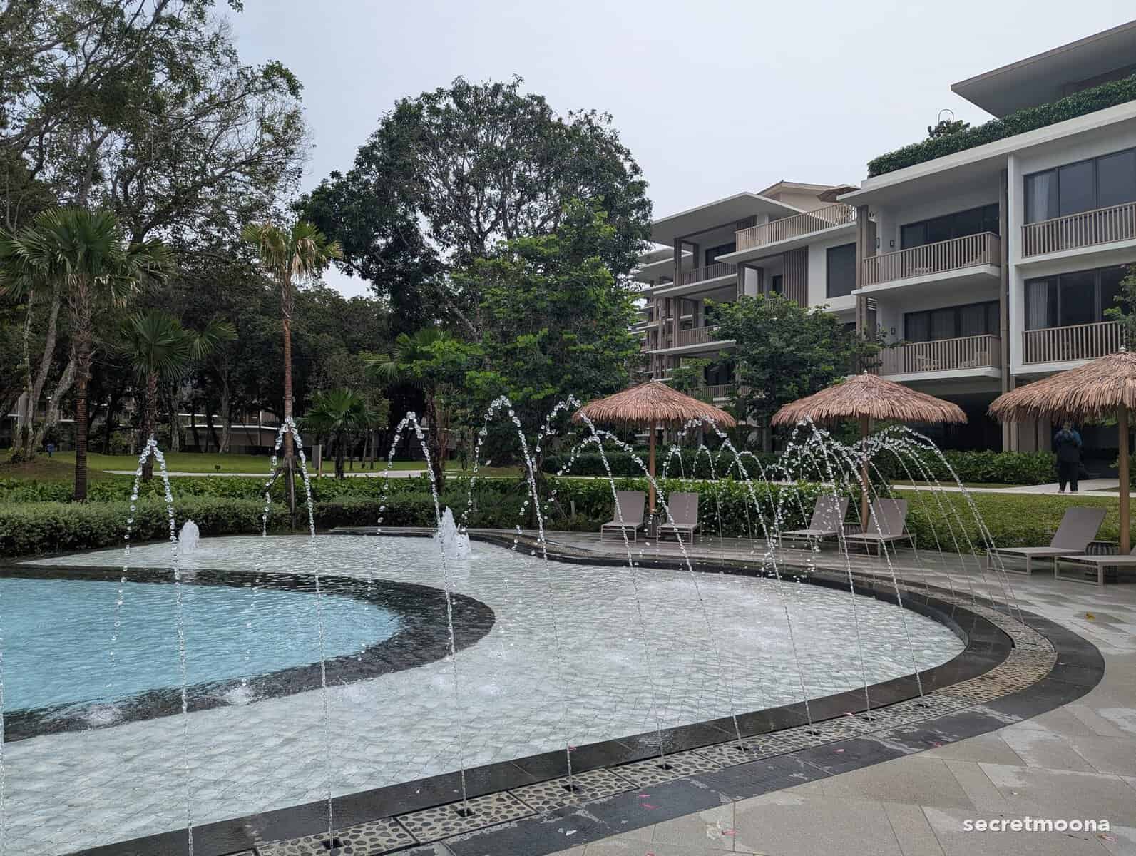 The family pool with water jets and thatched parasols at Hilton Burau Bay Langkawi