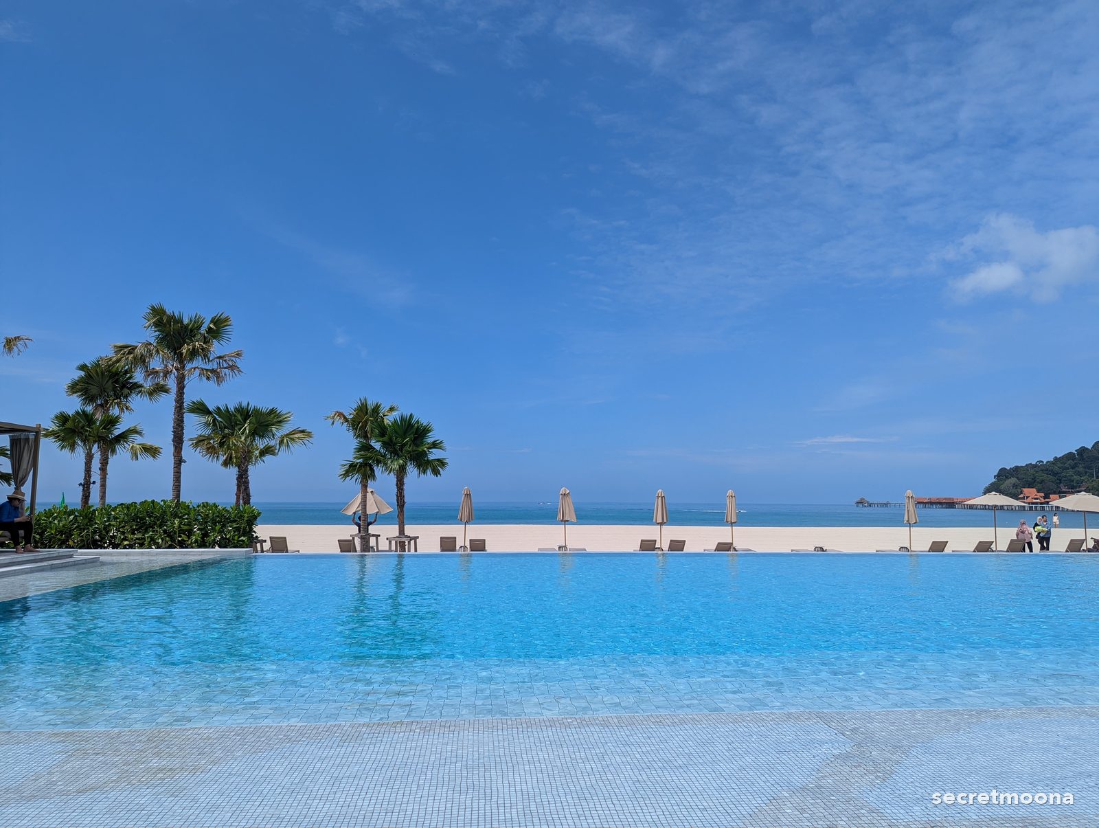 A palm-lined infinity pool facing the Andaman Sea at Hilton Burau Bay Langkawi