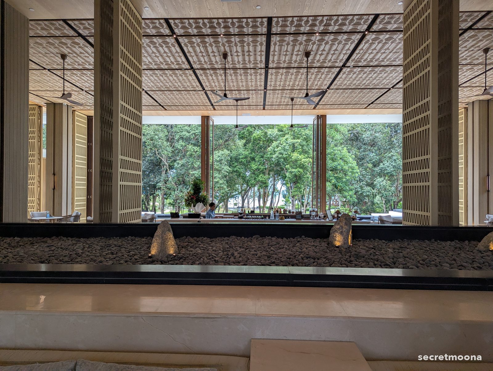 A long gallery with latticed timber screens and a planted trough at Hilton Burau Bay Langkawi