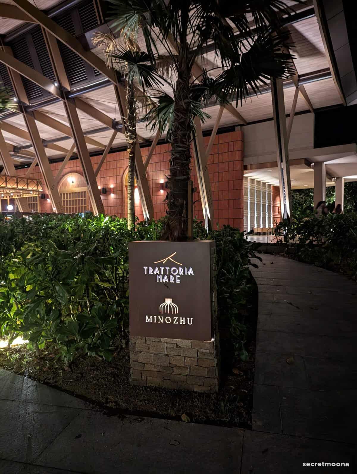 Illuminated signage for Trattoria Mare and MINGZHU restaurants at night