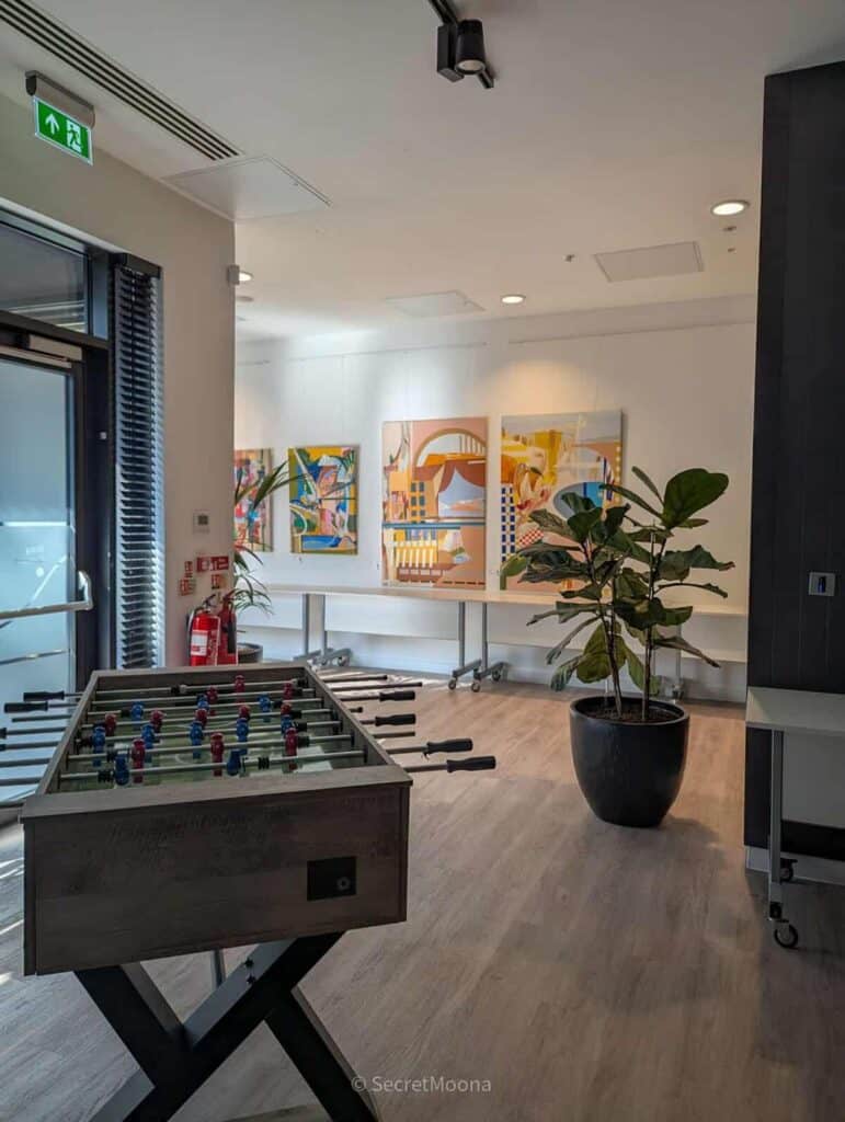 Meeting space with colourful artworks, a plant and a foosball table