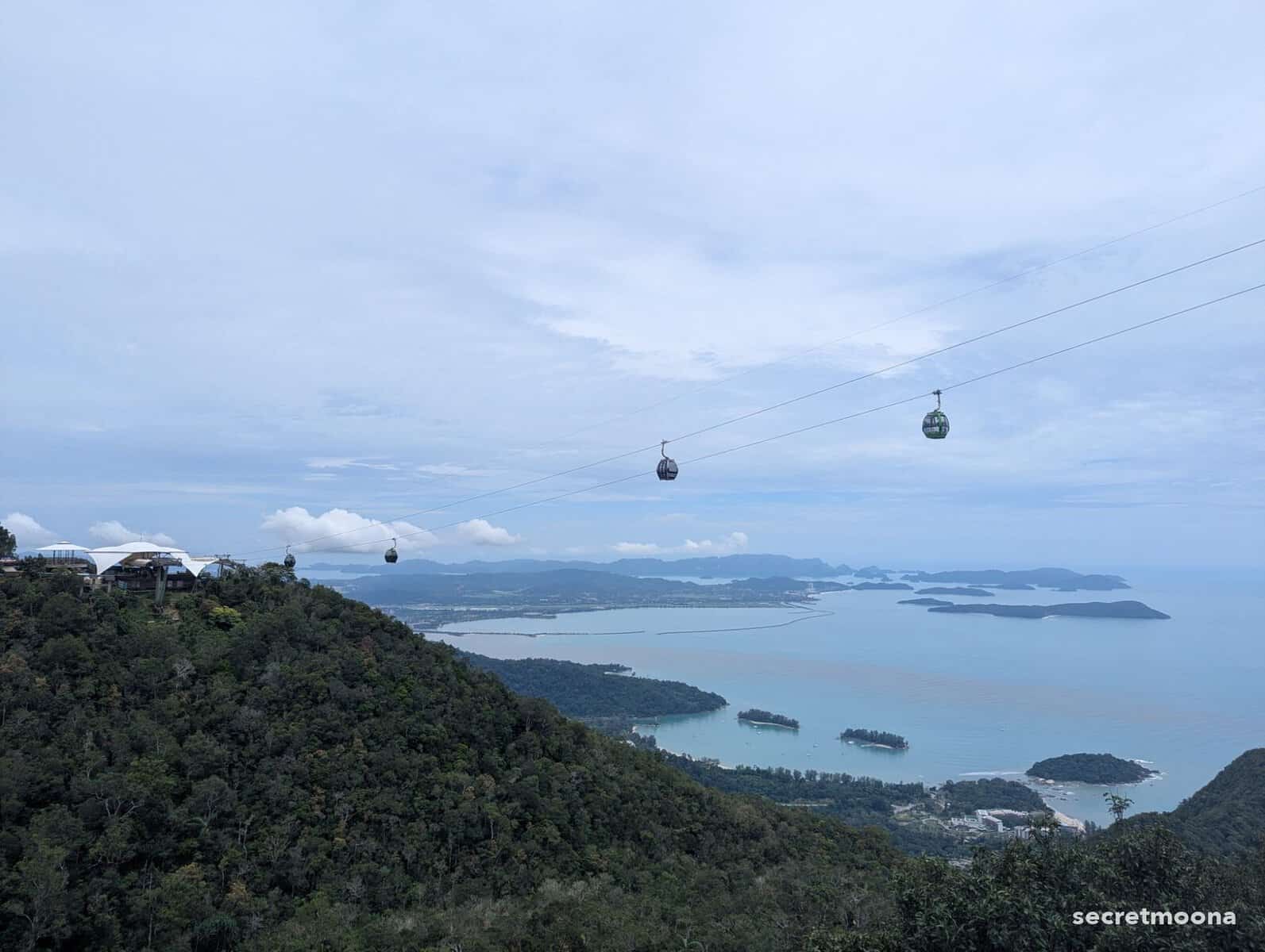 Green Panorama Langkawi SkyCab gondolas on the cable above the rainforest, with the bay and islands beyond
