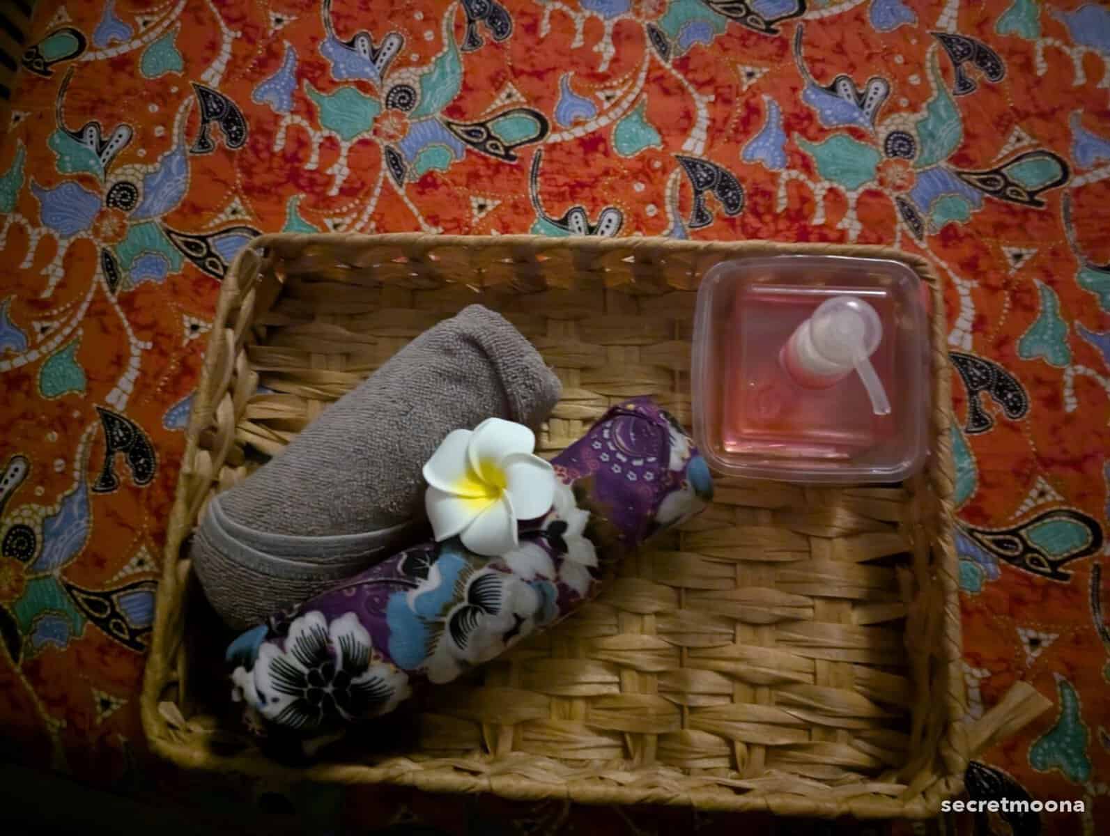 A rolled towel and frangipani flower laid out ready for a massage in Langkawi
